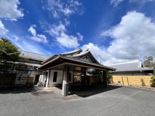 a building with a japanese roof on a street at ひこさんホテル和 in Hikosan