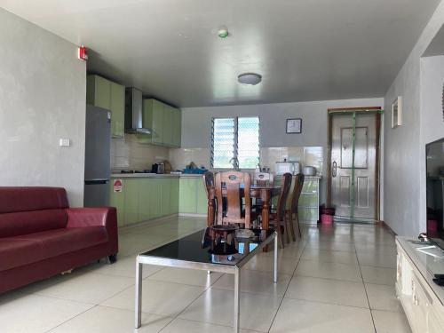 a living room with a couch and a table at Large two-bedroom apartment-free parking in Suva