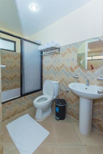 a bathroom with a toilet and a sink at Northland Resort Hotel Manapla in Busay
