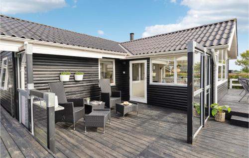 een terras met stoelen en een vuurplaats op een huis bij Bakkehuset in Hejls