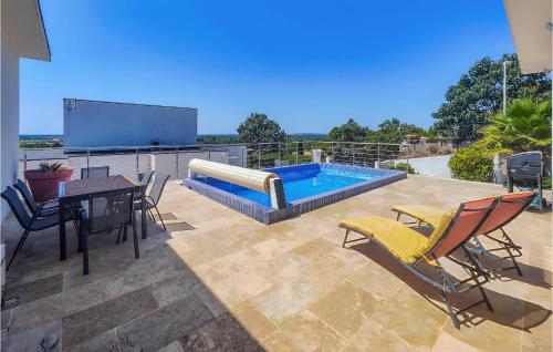 a patio with a table and chairs and a swimming pool at Stunning Home In Portiragnes in Portiragnes