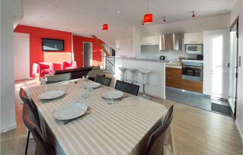 une table de salle à manger avec des chaises et une cuisine dans l'établissement Awesome Apartment In Planguenoual, à Planguenoual