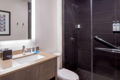 a bathroom with a toilet and a sink and a shower at Hyatt House New Orleans Downtown in New Orleans