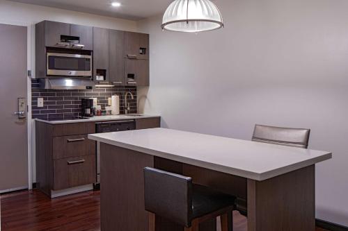 a kitchen with a table and chairs and a microwave at Hyatt House New Orleans Downtown in New Orleans