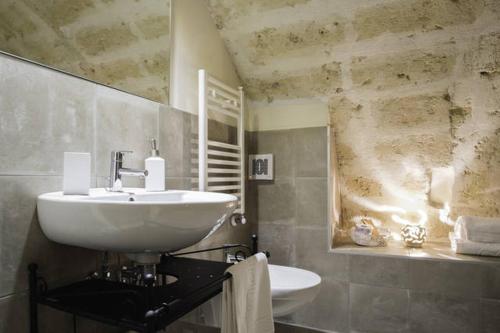 a bathroom with a white sink and a mirror at Il Vento dei Sassi in Matera