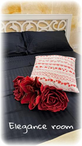 a bed with red roses on it with the words escape room at L'Edicola - SUITE - in Pulsano