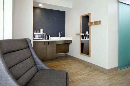 a living room with a chair and a microwave at Cambria Hotel Phoenix Chandler - Fashion Center in Chandler