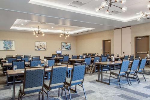 a conference room with tables and blue chairs at Cambria Hotel Phoenix Chandler - Fashion Center in Chandler