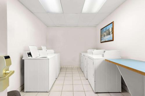 a laundry room with white washers and dryers at Clarion Suites Anchorage Downtown in Anchorage