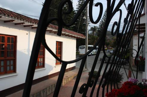 a wrought iron fence in front of a white building at Hotel El Parque HR in Fómeque