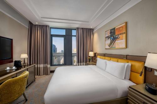 a hotel room with a large bed and a television at The Hotel Galleria Jeddah, Curio Collection by Hilton in Jeddah
