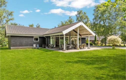 a house with a large yard with green grass at Holiday Home Bæverstien Xi Dnmk in Marielyst