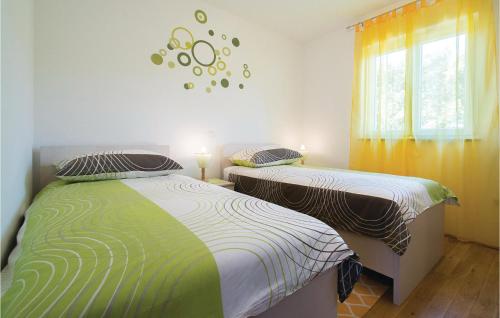 two twin beds in a bedroom with a window at Stunning Apartment In Labin With House Sea View in Labin