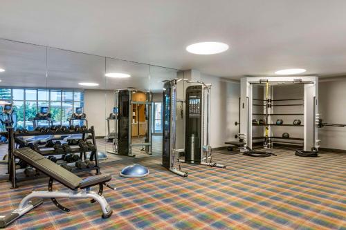 a gym with several treadmills and a mirror at Cambria Hotel LAX in El Segundo