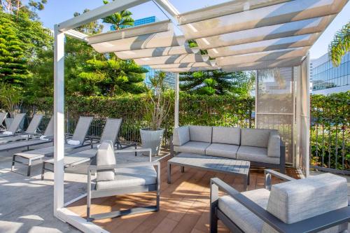 a patio with lounge chairs and a pergola at Cambria Hotel LAX in El Segundo