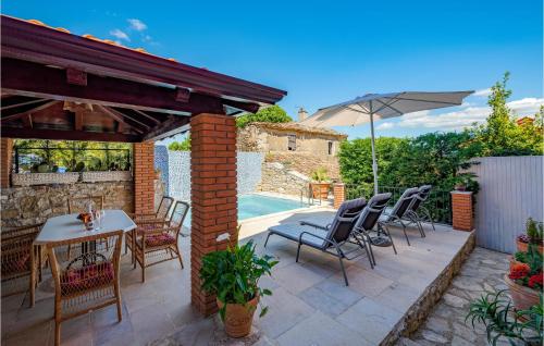 a patio with a table and chairs and an umbrella at Holiday Home Vizinada X in Vižinada