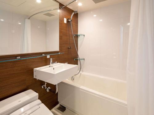a bathroom with a sink and a tub and a toilet at Comfort Hotel ERA Kyoto Toji in Kyoto
