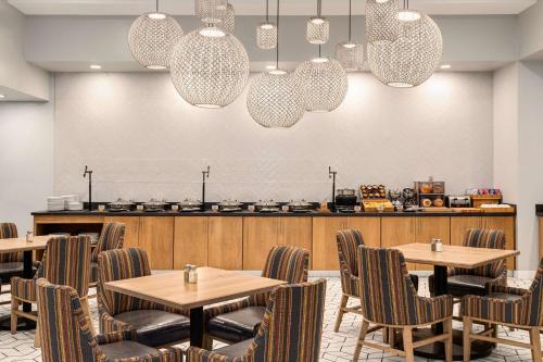 a dining room with tables and chairs and chandeliers at Doubletree by Hilton Fort Myers at Bell Tower Shops in Fort Myers