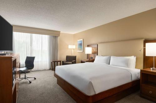 a hotel room with a large bed and a television at Doubletree by Hilton Fort Myers at Bell Tower Shops in Fort Myers