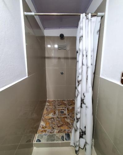 a shower with a white shower curtain in a bathroom at Hostal Sunset Town in Ahuachapán