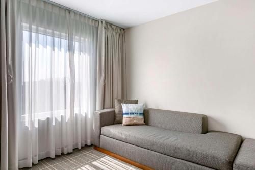 a living room with a couch and a window at Cambria Hotel LAX in El Segundo