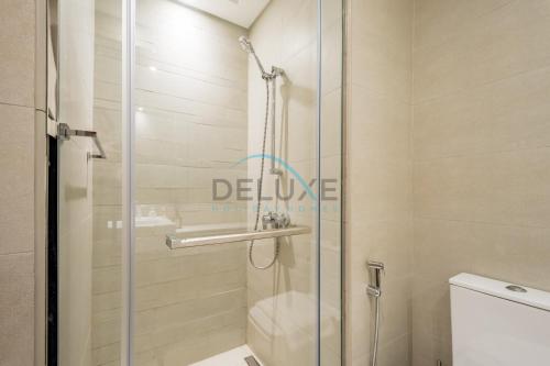 a shower with a glass door in a bathroom at Calming Studio Apartment at Azizi Riviera 4, Al Merkadh by Deluxe Holiday Homes in Dubai