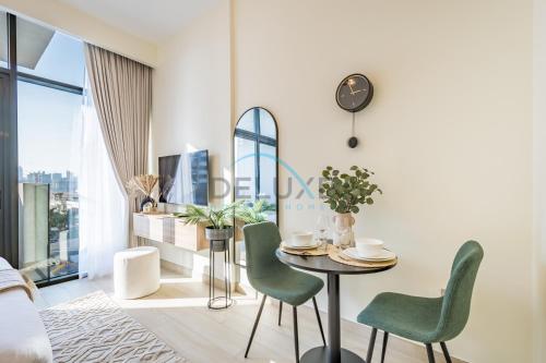 a living room with a table and chairs at Calming Studio Apartment at Azizi Riviera 4, Al Merkadh by Deluxe Holiday Homes in Dubai
