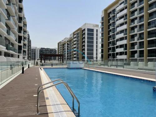 a swimming pool in the middle of some buildings at Calming Studio Apartment at Azizi Riviera 4, Al Merkadh by Deluxe Holiday Homes in Dubai