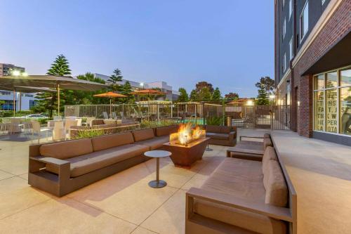 a patio with couches and a fireplace on a building at Cambria Hotel LAX in El Segundo