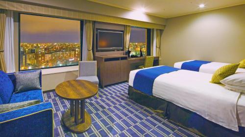 a hotel room with two beds and a window at Premier Hotel Nakajima Park Sapporo in Sapporo