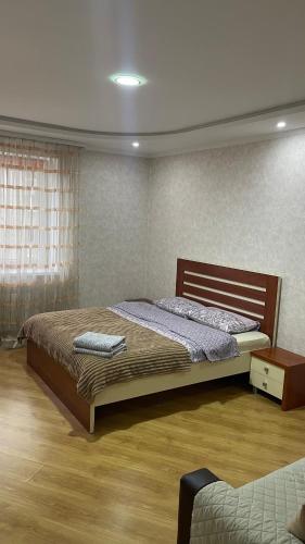 a bedroom with a large bed and a window at Квартира возле Автовокзала in Rivne