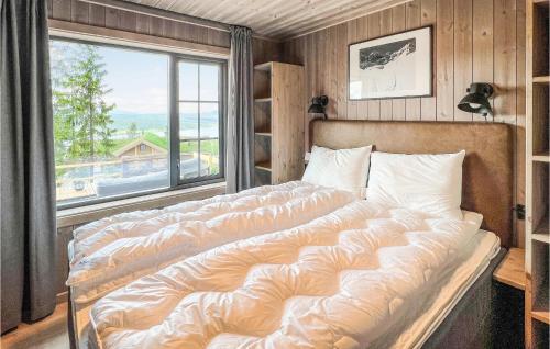a large bed in a room with a large window at Gorgeous Home In Gålå With Sauna in Gålå