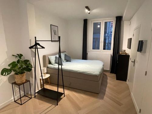 Un dormitorio pequeño con una cama y una ventana. en Stadsstudio op toplocatie, en Amberes
