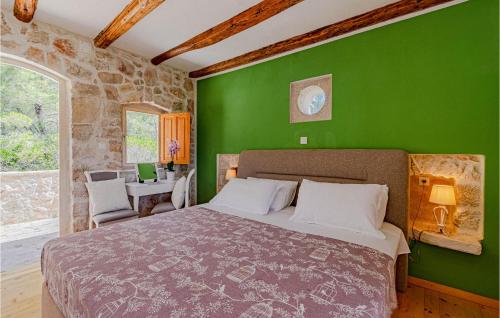 a green bedroom with a bed and a green wall at 2 Bedroom Lovely Home In Blato in Blato