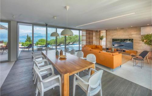 a dining room and living room with a table and chairs at Villa Elegant in Splitska