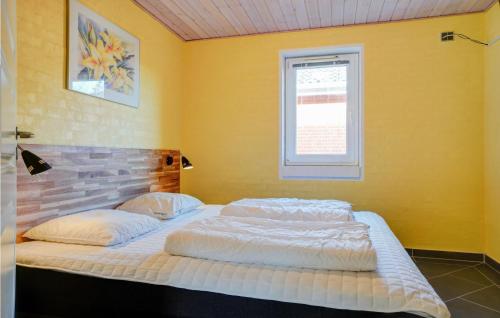 a bedroom with two beds in a yellow wall at Stunning Home In Spøttrup With Sauna in Vadum