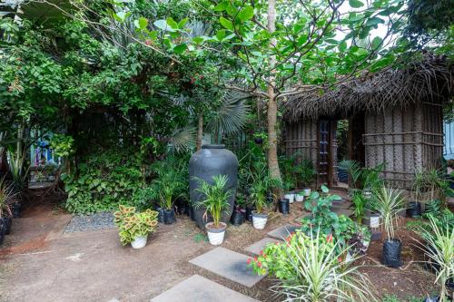 a garden with a large vase and a bunch of plants at Akasa Goa in Palolem