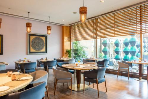 a restaurant with tables and chairs and a large window at Crowne Plaza Today Gurugram by IHG in Gurgaon