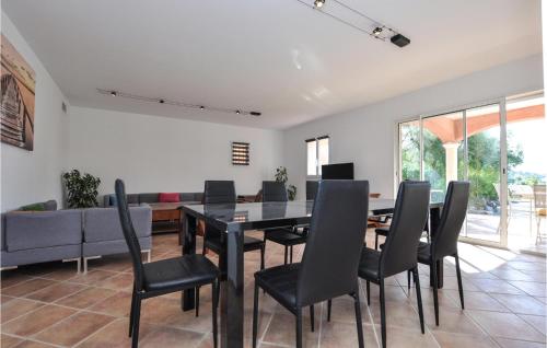 une salle à manger avec une table noire et des chaises noires dans l'établissement Pet Friendly Home In Cavalaire-Sur-Mer, à Cavalaire-sur-Mer