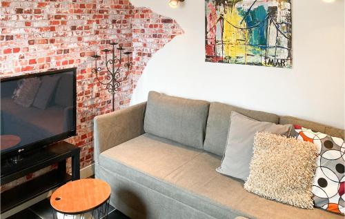 a living room with a couch and a brick wall at Gorgeous Home In Bunschoten-Spakenb in Bunschoten