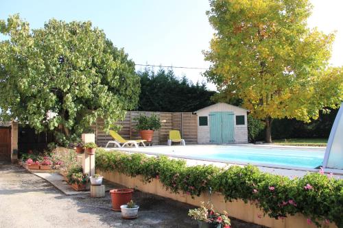 a backyard with a swimming pool and some plants at Sous Le Figuier in Saint-Siméon-de-Bressieux