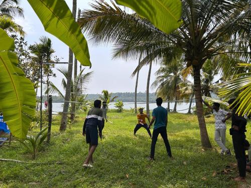 a group of people playing frisbee on the beach at Lake Homes in Varkala