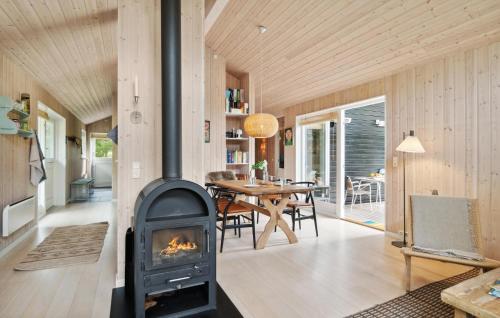 a fireplace in a living room with a table at 3 Bedroom Nice Home In Kalundborg in Kalundborg