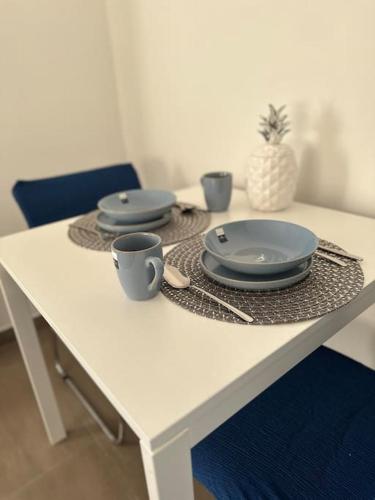 a white table with plates and cups on it at Ferien- Monteurwohnung in Förderstedt, Staßfurt in Staßfurt