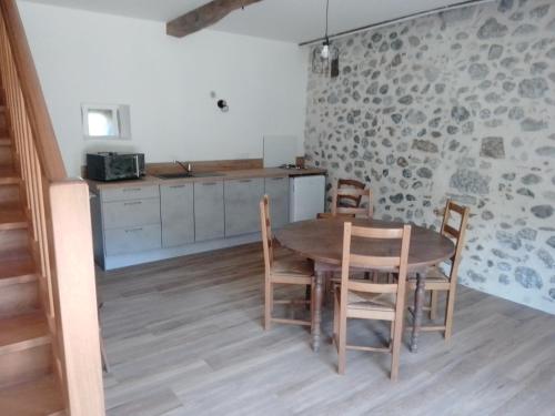 a kitchen with a table and chairs in a room at Gîte maison Chourrist in Capbis