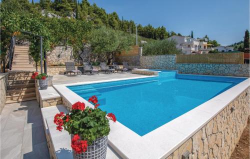 a swimming pool with red flowers next to a house at Apartment Blace With Sea View Xiii in Blace