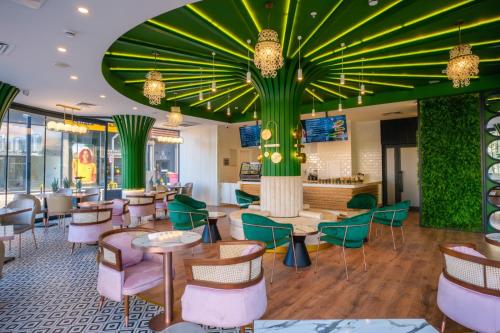 a restaurant with a green ceiling and tables and chairs at Caddem Inn Hotel in Mağusa