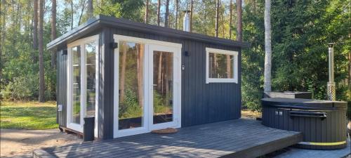 a black and white shed with a trash can at Varėnės sodyba in Vėžionys