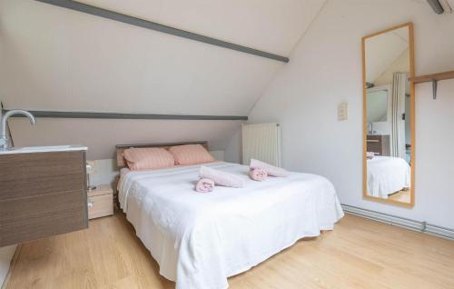 ein Schlafzimmer mit einem Bett mit rosa Kissen darauf in der Unterkunft Dophuisje in Egmond aan Zee
