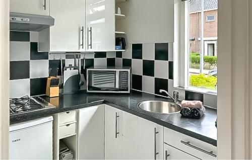 eine Küche mit schwarz-weiß karierten Wänden in der Unterkunft Dophuisje in Egmond aan Zee